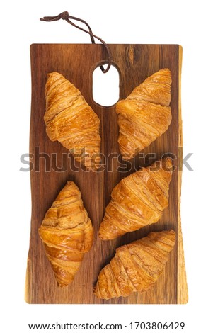 Fresh flavorous croissant on wooden table isolated on white