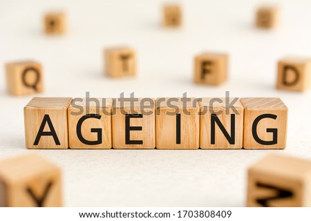 Ageing - word from wooden blocks with letters, growing old senescence ageing concept, random letters around white background Royalty-Free Stock Photo #1703808409