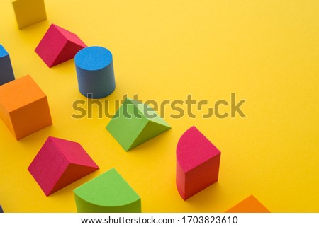 Set of colorful geometric cube or block toy on yellow background with copy space. Abstract pattern design composition by shape and form. Education, business solution, creative design product concept.
