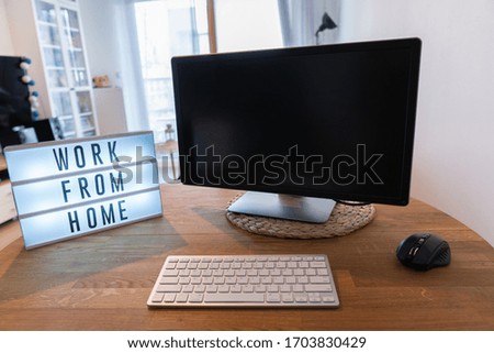Working from home remote work inspirational social media lightbox message board next to monitor and keyboard and mouse, COVID-19 quarantine closure of all. Apartment background