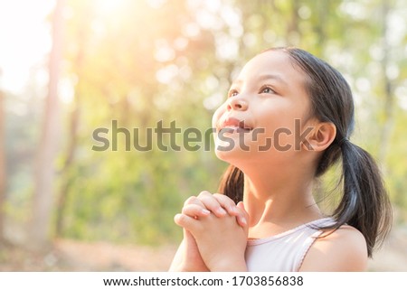 cute little girl hands praying to god with the bible in the morning on nature background.  little asian girl hand praying for thank god. copy space. spirituality and religion faith hope concept. Royalty-Free Stock Photo #1703856838