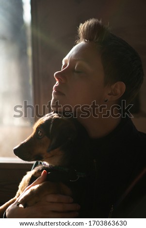young woman and dog by the window on quarantine self isolation