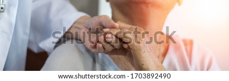 Geriatric doctor or geriatrician concept. Doctor physician hand on happy elderly senior patient to comfort in hospital examination room or hospice nursing home or wellbeing county.  Royalty-Free Stock Photo #1703892490