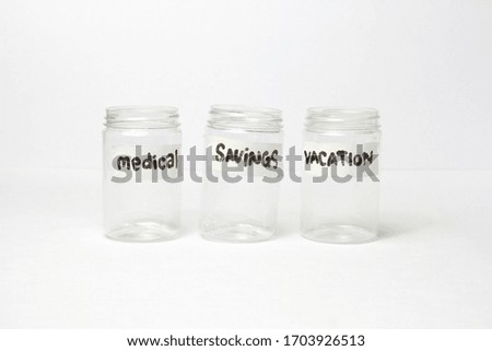 Transparent jar full coin with labeling salary, tax, savings, debt,medical,and vacation with financial planning conceptual.