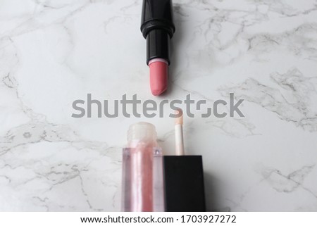 lipstick and lip gloss on marble background