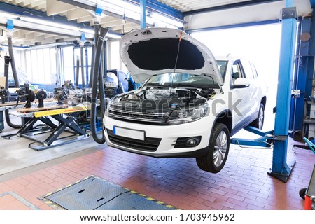 Cars on the lift of a workshop Royalty-Free Stock Photo #1703945962