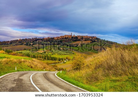 Rural tourism in the legendary Tuscany. Dirt road runs through the hills. Olive trees on green grassy meadows. The concept of active, rural and photo tourism