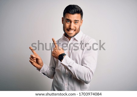 Young handsome man wearing elegant shirt standing over isolated white background Pointing aside worried and nervous with both hands, concerned and surprised expression