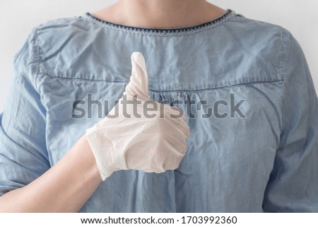 Close-up woman doctor hands in white medical rubber gloves on heart blue coat background. Disinfection, health, care, safety concept. Stop virus and coronovirus
