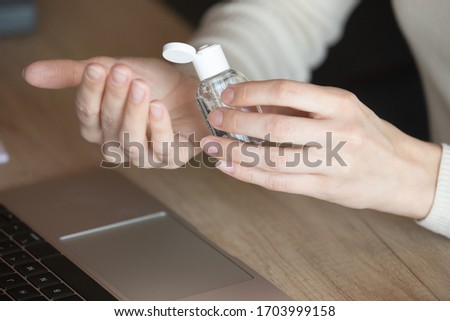 Close up of female employee work in office clean hands with antibacterial liquid gel at workplace, woman worker sanitize disinfect using sanitizer, take care during coronavirus covid-19 pandemic Royalty-Free Stock Photo #1703999158