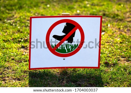 public sign to ban walking on green grass
