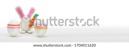 Plasticine Rabbit with easter egg and carrot. Horizontal long background.