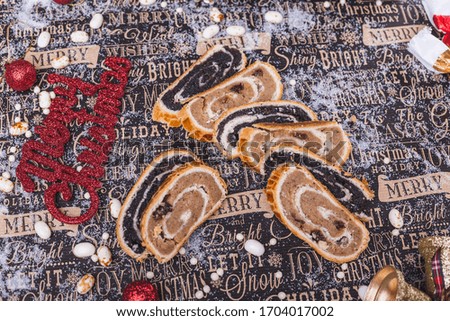 Traditional christmas food: slices of nuts and poppy seed rolls embraced with christmas decoration.