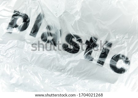 Black Plastic word on transparent white disposable plastic bag. Environment pollution problem concept image with copy space