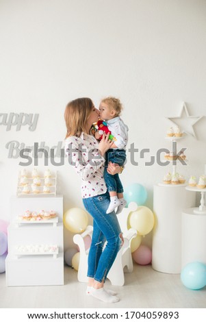 Young mother with her little cute son on his birthday at a children's party with balloons and cakes. Children's party. Balloons. Happy childhood
