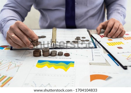 Office businessman working and analyzing company profits using charts and documents using coins.  Business Analysis and Strategy Concept