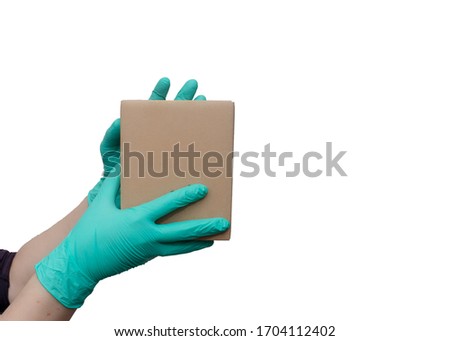 Woman's hands with medical protective gloves holding cardboard box on white background