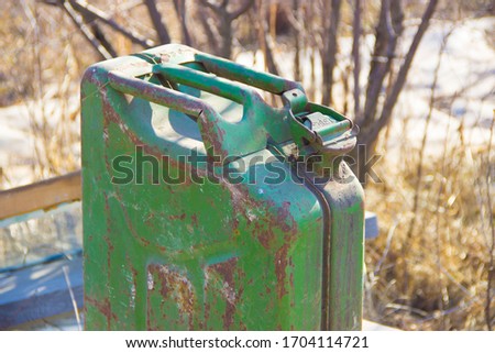 Old metal canister of green color from under the fuel, peeling paint