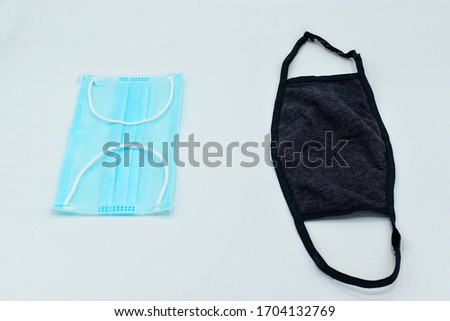 Reusable black cloth mask or cotton mask vs Surgical mask or medical mask. Comparing differences. Isolated on white background.