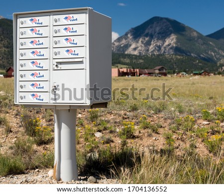 Metal mailbox container for rural homes with I Voted stickers as concept for voting by mail or absentee ballot paper Royalty-Free Stock Photo #1704136552