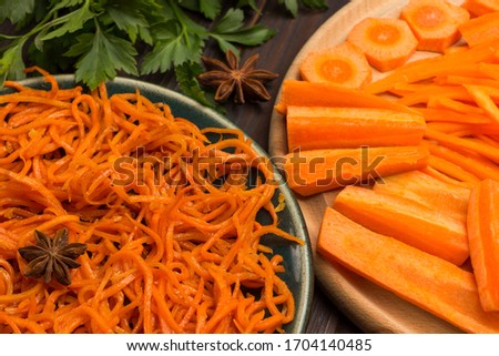 Fresh chopped carrots on cutting board. Fermented carrots in plate. Natural remedy for boosting immune system. Close up. Dark wooden background 
