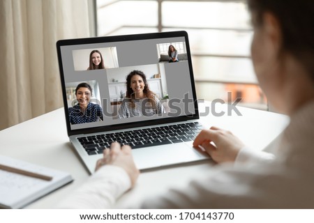 Modern tech communication application, international friendship, distant chat, easy convenient comfort usage concept, laptop screen view over woman shoulder while sit at desk and look at pc monitor Royalty-Free Stock Photo #1704143770