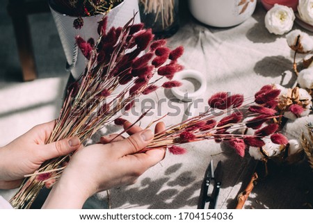 
Florist makes a bouquet of dried flowers Royalty-Free Stock Photo #1704154036