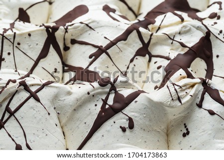 Stracciatella flavour gelato - full frame detail. Close up of a white surface texture of stracciatella Ice cream covered with chocolate stripes and dots.