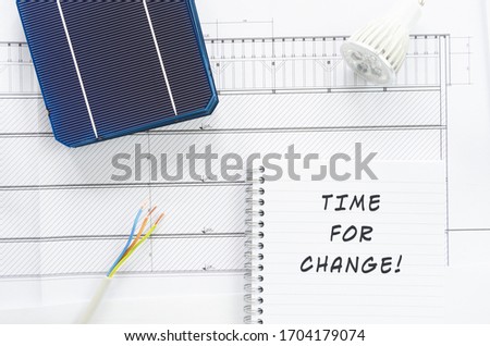 Solar cells, wires, led bulb and note pad with sign Time For Change in a conceptual image of changing energy policies