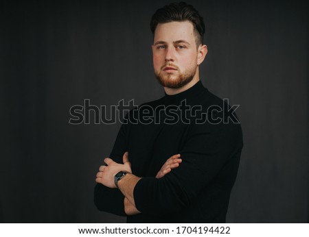 Man posing in studio in front of gray backdrop