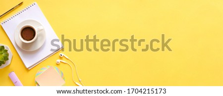 flat lay composition with notebook, coffee, plant, stickers on yellow background. Concept remote study and work at home, telework, freelance, quarantine. Coffee break, office table. Copyspace, banner