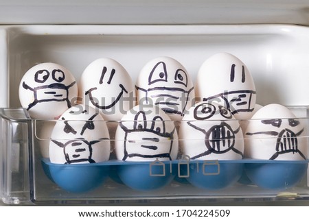 quarantine easter concept. close up of diverse chicken easter eggs with doodle emotional faces wearing medical masks crowding in fridge door