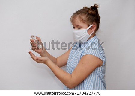 Protection from infectious diseases, coronavirus. A girl in a medical protective mask with an antibacterial antiseptic gel for hand disinfection on a white background. Health care prevention during an