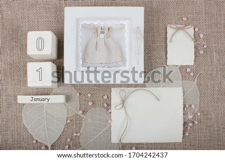 Calendar. January 1st. Wood cube calendar with date of month and day. Newborn postcard concept for girls with copy space. Birthday concept. Greeting or invitation card. 