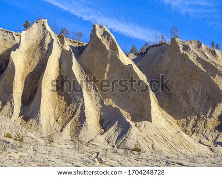 Abandoned Quarry Of Rummu, Estonia. Scenic View Of Land Against Clear Blue Sky. Mountain of white sand.and stones. Panoramic View. The erosion of limestone quarry. Sandy hill.