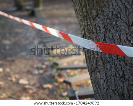 Barrier tape, warning red and white around the tree