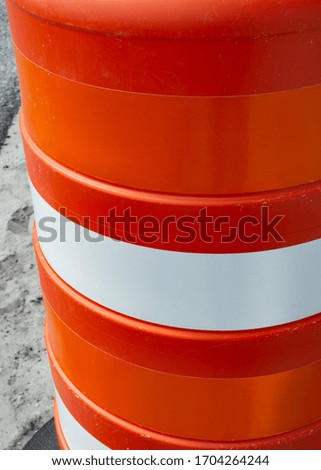 Close-up orange and white traffic barrel
