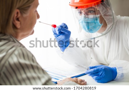 Physician wearing personal protective equipment performing a Coronavirus COVID-19 PCR test, patient nasal NP and oral OP swab sample specimen collection process, viral rt-PCR DNA diagnostic procedure Royalty-Free Stock Photo #1704280819