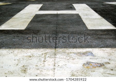 Helicopter helipad with white marker painted on the asphalt concrete ground