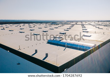 Large roof of factory with roof ventilators, drone shot from above Royalty-Free Stock Photo #1704287692