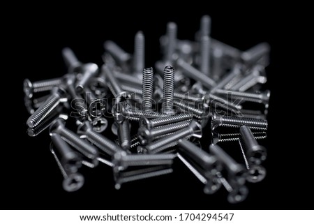 Macro small screws on a black background with reflection