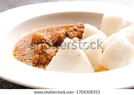 A selective focus picture of "nasi impit" or pressed rice with "kuah kacang" or peanut sauce. Traditional Malay Nusantara food usually serve during Eid or snack.