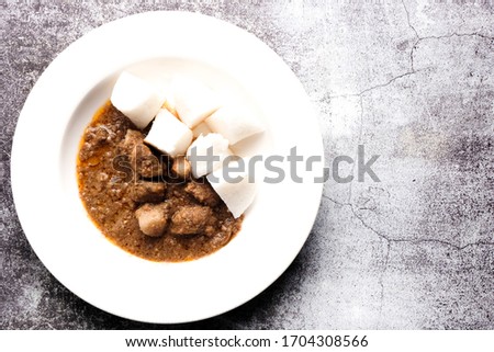 A flatlay and copy space picture of "nasi impit" or pressed rice with "kuah kacang" or peanut sauce. Traditional Malay Nusantara food usually serve during Eid or snack.