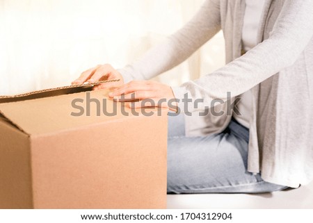 Stock photo of the hands of a woman opening a box. Photo with copy space representing online shopping.