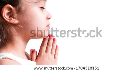 Isolated little girl praying in the morning as a banner. Hands folded in prayer concept for faith, spirituality and religion. Pray for god blessing wishing have better life Christians together.
