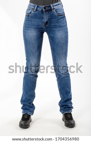 girl in jeans shows jeans on a white background close-up, blue jeans