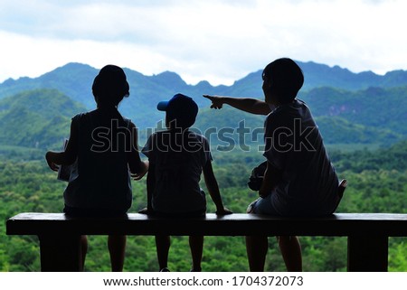 Family relations, silhouette picture of the mother and both children point to see interesting things.