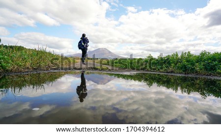 Reflection in water pond, Woman take a picture view Mountain landscape among cloudy in blue sky by medium format camera    