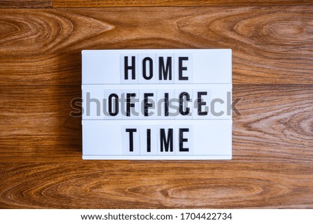 lightbox with text HOME OFFICE TIME in front wooden background, copy space, banner for freelance coronavirus covid-19 quarantine isolation, teleworking