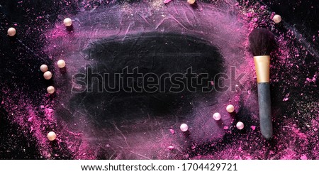 A make-up panorama. A brush with crushed cosmetics on a black background, with copy space, a beauty frame for a makeup school